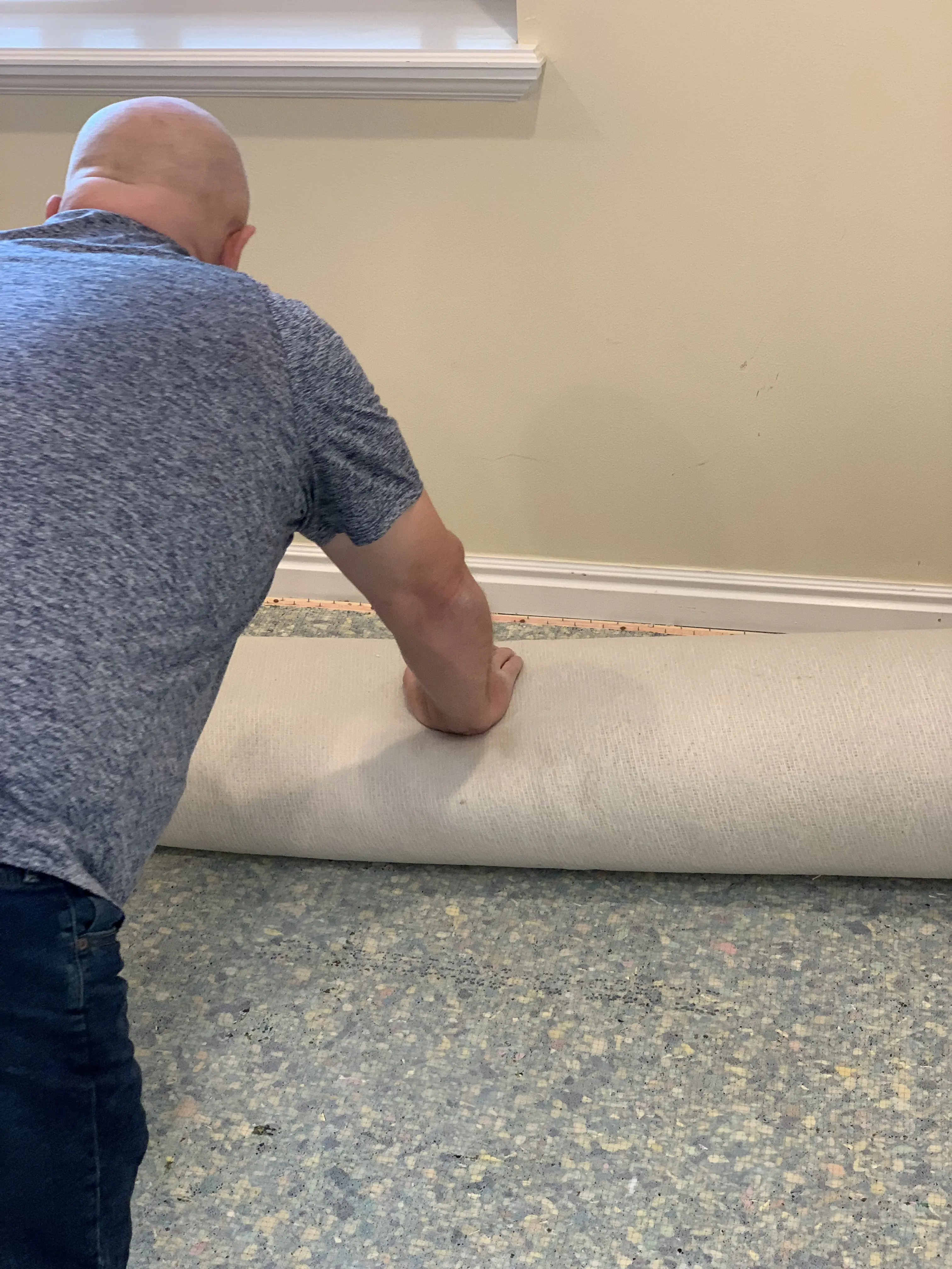 ModJobs helper rolling up the old carpet for haul-away